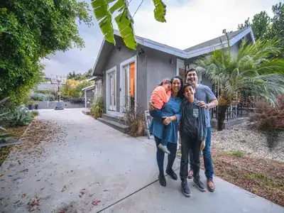 Familia hispana recibiendo llaves de su primera casa